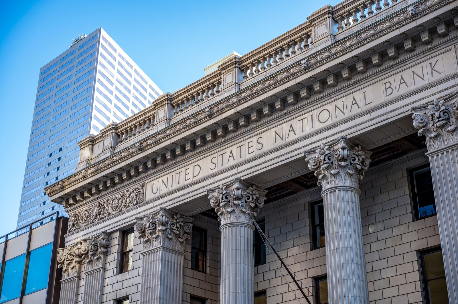 Classical bank facade with stone columns against a blue sky